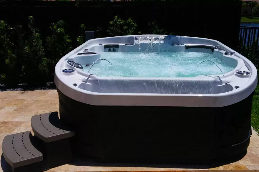 Spa à debordement installé sur une terrasse en pierre / Coast Spa - Modèle : Cascade II