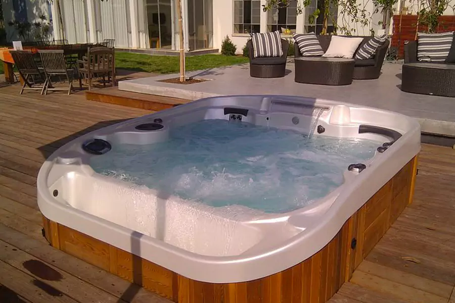 Spa à debordement installé sur une terrasse en bois / Coast Spa